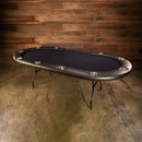 Poker table with a dark surface against a wooden wall.